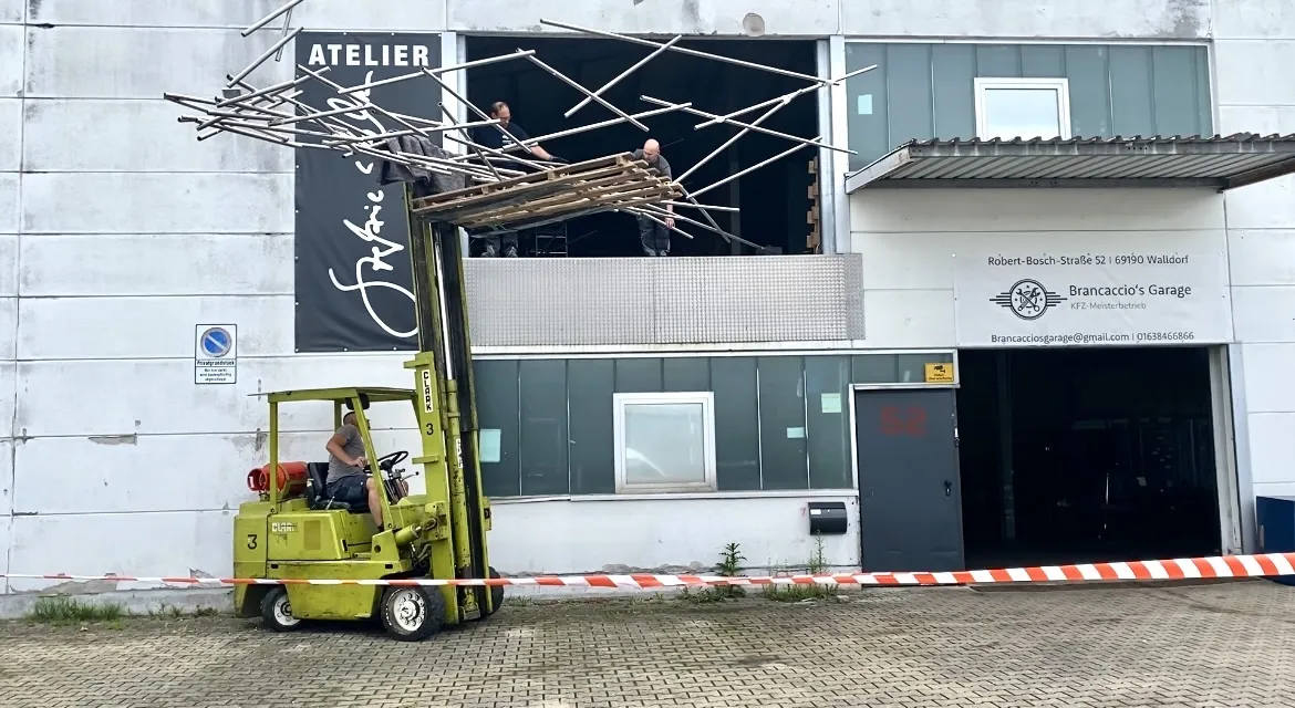 Per Gabelstapler wird eine Hälfte von IMPACT aus dem Atelier bugsiert.